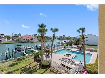 Scenic aerial view showcasing the waterfront with boat docks, a community pool, and lush landscaping at 363 Pinellas Bayway S # 41, Tierra Verde, FL 33715