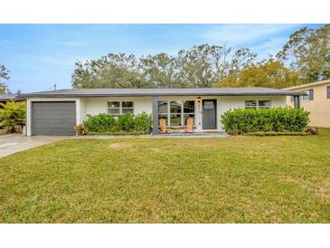 Charming single-story home featuring a well-manicured lawn and inviting front entrance with outdoor seating at 4519 S Hesperides St, Tampa, FL 33611