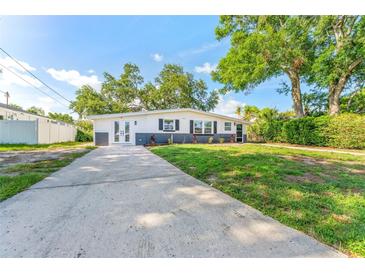 Charming single-story home with a well-maintained lawn and spacious driveway at 8703 Driftwood Dr, Tampa, FL 33615