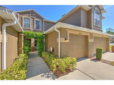 Charming home exterior featuring a lush, vine-covered entryway and a two-car garage at 18827 Duquesne Dr, Tampa, FL 33647