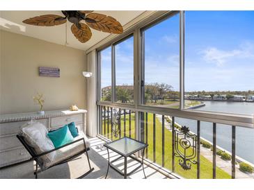 Relaxing balcony with water view, rattan ceiling fan, and comfortable seating area at 19029 Us Highway 19 N # 8-18, Clearwater, FL 33764