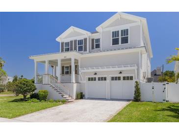 Charming two-story home with a covered front porch, two-car garage and well manicured lawn at 323 Appian Ne Way, St Petersburg, FL 33704