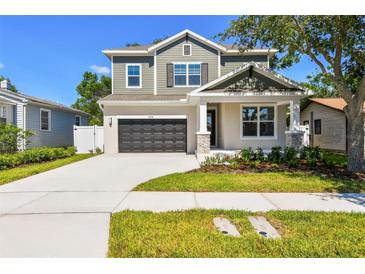 Charming two-story home featuring a gray exterior, well-manicured lawn, and an attached two-car garage at 3218 21St N St, St Petersburg, FL 33713