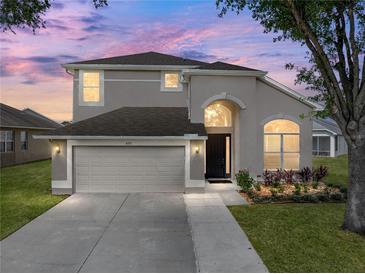 Charming two-story home featuring a well-manicured lawn, a two-car garage, and neutral stucco exterior at 4351 Highcroft Dr, Wesley Chapel, FL 33545