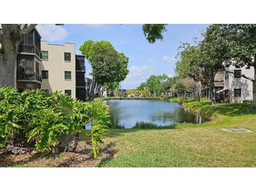 Scenic exterior view of waterfront property with well-maintained landscaping and lush green trees at 5975 Terrace Park N Dr # 102, St Petersburg, FL 33709
