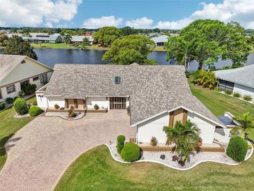 Beautiful waterfront home with brick driveway, meticulous landscaping, and a skylight at 1928 E View Dr, Sun City Center, FL 33573
