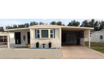 Charming single-story home featuring a large covered parking area and well-maintained front yard at 322 S Port Royal Ln, Apollo Beach, FL 33572