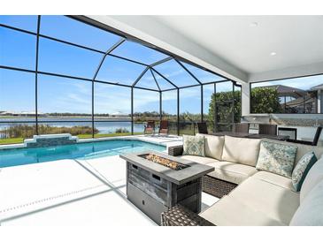 Relaxing screened-in lanai featuring a gorgeous pool, outdoor seating area, and tranquil lake views at 12425 Glenridge Ln, Parrish, FL 34219