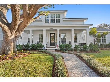 Charming two-story home with a welcoming porch, swing, beautiful landscaping, and a brick walkway at 120 25Th N Ave, St Petersburg, FL 33704