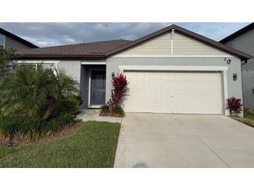 Charming single-story home featuring a two-car garage and well-manicured lawn at 6684 Devlin Ln, Wesley Chapel, FL 33545