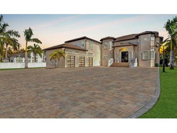 Elegant two-story home with a three-car garage, beautifully landscaped yard, and a spacious brick driveway at 9401 93Rd St, Seminole, FL 33777