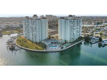 Waterfront condominium complex with towers, a pool, tennis court, and lush landscaping on a peninsula at 420 64Th Ave # 1005, St Pete Beach, FL 33706