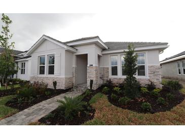 Charming single-story home featuring stone accents, well-maintained landscaping, and a paved walkway to the front door at 695 Allora Ave, Nokomis, FL 34275