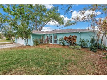 Charming single-story home with a manicured lawn and lush landscaping at 13851 102Nd Ave, Largo, FL 33774
