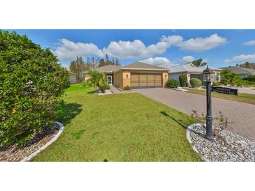 Charming single-story home with a well-manicured lawn and a brick driveway, situated in a tranquil neighborhood at 1123 Emerald Dunes Dr, Sun City Center, FL 33573
