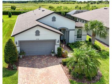 Charming single-Gathering home featuring a well-manicured lawn, brick driveway, and two-car garage at 4748 Ballast Crest Cv, Land O Lakes, FL 34638