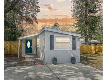 Charming home showcasing a welcoming entryway, fresh exterior paint, and a well-manicured landscape at 1214 Orange Ave, Dunedin, FL 34698