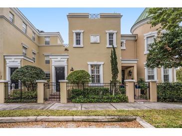 Elegant townhome featuring a manicured front yard with a wrought iron fence and tasteful landscaping at 2419 Victoria Gardens Ln, Tampa, FL 33609