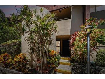 A charming entrance with lush tropical landscaping and a well-maintained facade at 880 S Village Lake N Dr # 106, St Petersburg, FL 33716