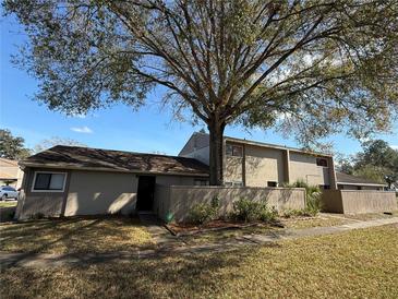 Charming townhome with a large tree, fenced in yard and neutral colored paint at 8608 Lake Isle Dr # 0, Temple Terrace, FL 33637