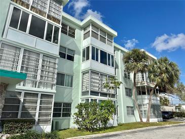 A well-maintained condo building with large windows and tropical landscaping at 100 Waverly Way # 302, Clearwater, FL 33756
