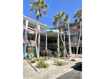 A multi-story condominium building features a beautiful entry and surrounding landscaping at 4300 58Th N St # 1909, Kenneth City, FL 33709