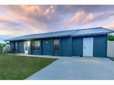 Charming single-story home with a well-maintained lawn, long driveway, and metal roof at 5108 Redwood Ter, North Port, FL 34286