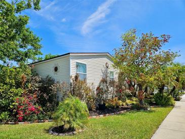 Charming home with well-maintained lawn, lush flower beds, and a decorative sunburst accent at 8326 Fantasia Park Way, Riverview, FL 33578