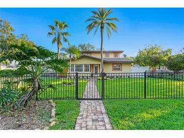 Charming home with lush lawn, tropical foliage, and secure black metal fencing, perfect curb appeal at 156 29Th N Ave, St Petersburg, FL 33704