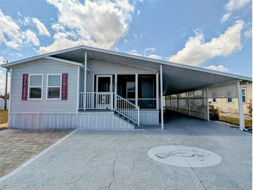 Charming single-story home with a covered carport and a decorative manatee design on the driveway at 206 S Port Royal Ln, Apollo Beach, FL 33572
