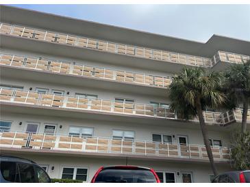 Multi-story condo building featuring balconies with decorative privacy screens and mature palm trees at 5603 80Th N St # 512, St Petersburg, FL 33709