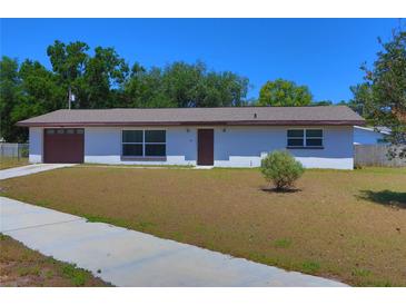 Single story home with a well kept lawn and mature trees on a sunny day at 5729 13Th St, Zephyrhills, FL 33542