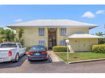 Two-story condo building with yellow siding, a light-colored roof and assigned parking at 7300 Sunshine Skyway S Ln # 202, St Petersburg, FL 33711