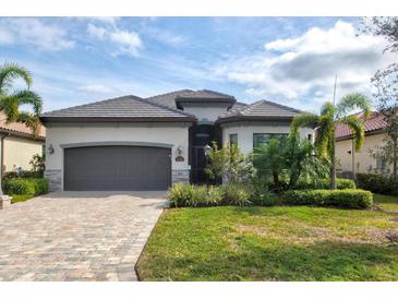 Beautiful single-story home with a paver driveway, two-car garage, tile roof, and well manicured landscaping at 5749 Cheech Gln, Bradenton, FL 34211