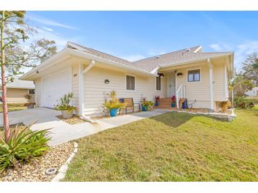 Charming single-story home featuring well-maintained landscaping, a welcoming entrance, and attached garage at 1007 Lake Avoca Dr, Tarpon Springs, FL 34689