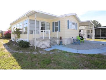 Charming home featuring a covered porch, brick foundation, and well-maintained landscaping at 114 W Saint Johns Way, Apollo Beach, FL 33572