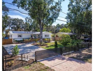 Charming single-story home featuring solar panels, a gravel driveway, and lush landscaping enhancing curb appeal at 3087 Duane Ave, Oldsmar, FL 34677