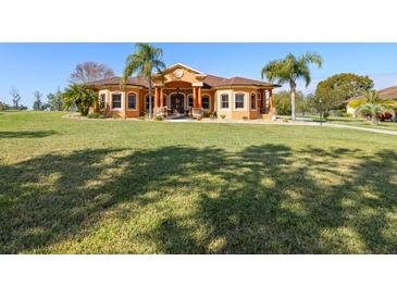 Beautiful single-story home featuring a sprawling lawn, mature trees, and a welcoming facade with a grand entrance at 14739 Vista View Ct, Dade City, FL 33523