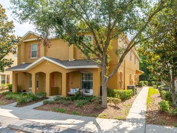 Inviting two-story home featuring a covered front porch with comfortable seating area and mature landscaping at 4734 Chatterton Way, Riverview, FL 33578