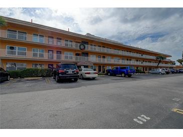 Three-story condo building featuring balconies, multiple parking spaces and well-maintained landscaping at 6400 46Th N Ave # 307, Kenneth City, FL 33709