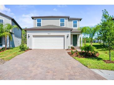Charming two-story home with a brick driveway, well-manicured lawn, and a two-car garage at 10822 Windswept Garden Way, Tampa, FL 33647
