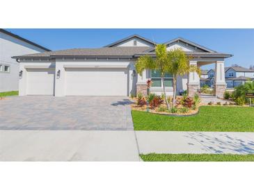 Charming single-story home featuring a three-car garage, well-manicured lawn, and inviting curb appeal at 33277 Rosewood Bark Way, Wesley Chapel, FL 33545