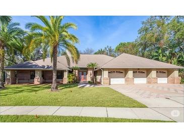 Beautiful single-story home featuring a three-car garage, mature landscaping, and a well-maintained lawn at 70 Deerpath Dr, Oldsmar, FL 34677