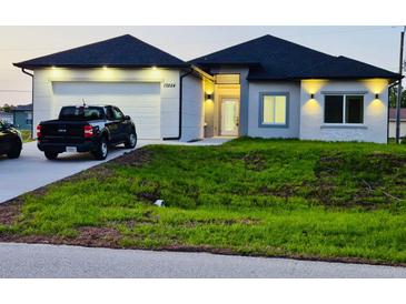 Charming single-story home with well-maintained lawn, attached garage, and modern design features at 13224 Foresman Blvd, Port Charlotte, FL 33981