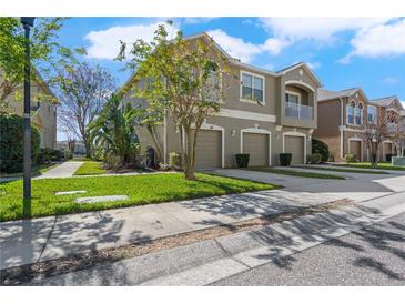 Charming three-car garage townhome with a manicured lawn and private second story balcony at 8835 Moonlit Meadows Loop, Riverview, FL 33578