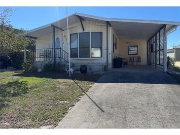 Charming single-story home with a covered parking area and well-maintained front yard at 4747 Bobby Ave # 258, Zephyrhills, FL 33541