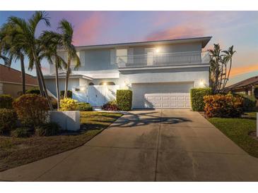 Charming two-story home with landscaped yard, two-car garage, and balcony at 727 Key Royale Dr, Holmes Beach, FL 34217