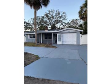 Charming single-story home with attached garage and well-maintained front yard and long driveway at 4935 Amherst Ct, New Port Richey, FL 34652