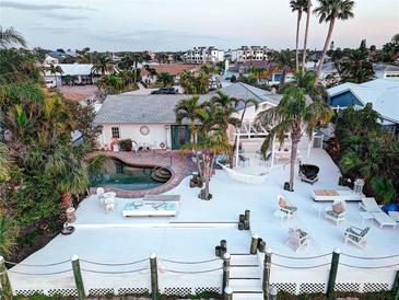 A stunning waterfront property with a beautiful pool, spacious deck, and lush tropical landscaping perfect for outdoor living at 6446 Lake Sunrise Dr, Apollo Beach, FL 33572