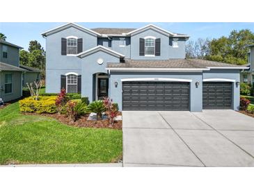 Beautiful two-story home featuring a well-manicured lawn and three-car garage at 4446 Wildstar Cir, Wesley Chapel, FL 33544